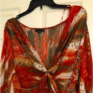 Pretty orange cream and brown dress. Sleeves fall to the elbow. Flowy fabric.